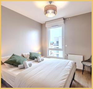 um quarto com uma grande cama branca e uma janela em Appart T3 Moderne Ambilly em Ambilly