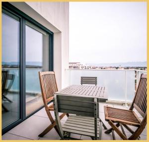 una mesa y sillas en un balcón con vistas al océano en Appart T3 Moderne Ambilly en Ambilly