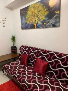 a living room with a couch with two red pillows at Stay Cay Affordable Price by -Mang Domeng in Manila