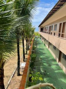a row of palm trees in front of a building at Long Island in Ilha Comprida