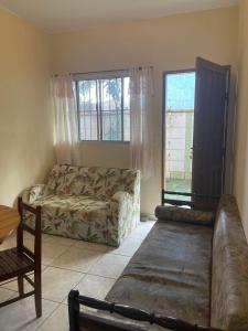 a living room with a couch and two windows at Long Island in Ilha Comprida