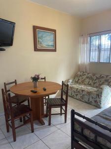 a living room with a table and chairs and a couch at Long Island in Ilha Comprida