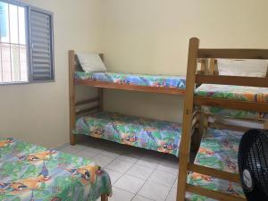 a room with three bunk beds and a window at Long Island in Ilha Comprida