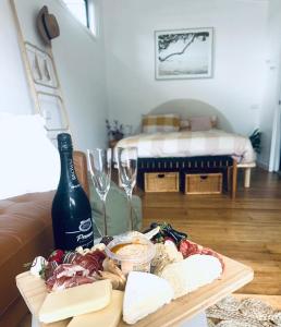 'NEL' - Rye Beach Studio Retreat في راي: طاولة مع زجاجة من النبيذ وكؤوس النبيذ