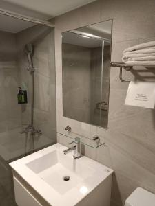 a bathroom with a white sink and a mirror at Mu Chen Hotel in Kaohsiung