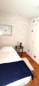 Schlafzimmer mit einem Bett und einem Beistelltisch in der Unterkunft Casa da Cris Quiron in São Paulo