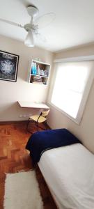 Schlafzimmer mit einem Bett, einem Schreibtisch und einem Fenster in der Unterkunft Casa da Cris Quiron in São Paulo