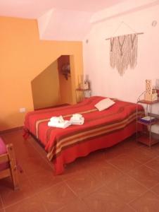 a bedroom with a red bed with towels on it at Ipay Alojamiento Familiar in Purmamarca