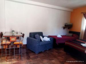 sala de estar con sofá, mesa y cama en Ipay Alojamiento Familiar en Purmamarca