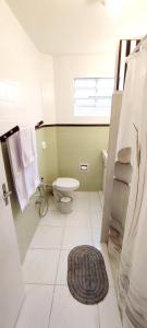 ein Badezimmer mit einem WC und einem Teppich in der Unterkunft Casa da Cris Quiron in São Paulo