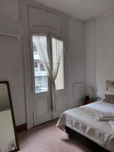 a bedroom with a bed and a large window at Hotel europeo in Buenos Aires