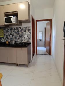 a kitchen with a counter top and a microwave at Temporada Peterle | AP 101 Irirí in Anchieta +23 photos