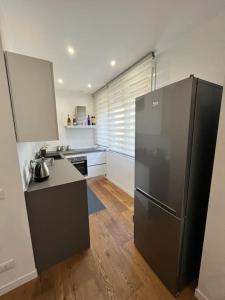 a kitchen with a black refrigerator in a room at Lazio apartment nel centro di Palermo in Palermo