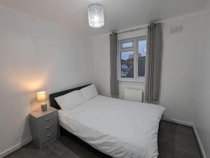 a small bedroom with a bed and a window at 3 Bedroom Apartment Sleeps 8 in Edinburgh