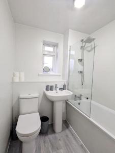 a white bathroom with a toilet and a sink at 3 Bedroom Apartment Sleeps 8 in Edinburgh