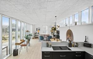 cocina y sala de estar con techos blancos y ventanas en Cozy Home In Aakirkeby With Kitchen en Vester Sømarken