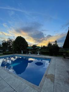 a swimming pool with a sunset in the background at Quinta Suria in Quito