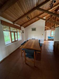 Habitación grande con mesa de madera y sillas. en Quinta Suria, en Quito