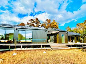 una casa modular con un gran grupo de ventanas en くろまま, en Oshima