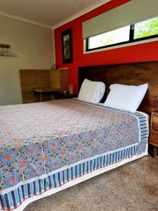 a bedroom with a large bed with red walls at Wompoo Eco Retreat in Cow Bay