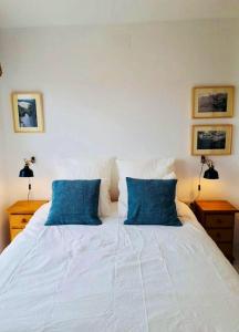 a bedroom with a white bed with blue pillows at One bedroom appartement with wifi at Cartagena in Cabo de Palos