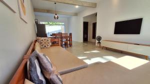 uma sala de estar com um sofá e uma televisão em Casa do Villas - Arraial d'Ajuda em Arraial d'Ajuda