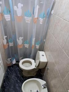 uma casa de banho com um WC e uma cortina de chuveiro em Casona con Barbacoa en Av princ em Montevidéu