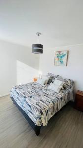 a bedroom with a bed in a white room at Departamento completo a pasos del mar in La Serena