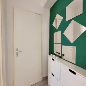 a room with a green and white wall with a mirror at La casa di Giada in Calatabiano