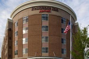 Um edifício com uma bandeira americana à frente. em Residence Inn by Marriott Fairfax City em Fairfax