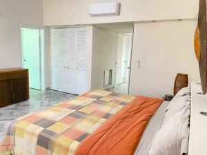 Un dormitorio con una cama con una manta de colores. en Dpto de lujo costera, en Acapulco
