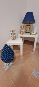 a room with two white tables and a lamp at La Casa sulla Piazza in Sciacca