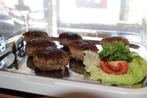 a tray of meatballs with a tomato and lettuce at Parkhotel Framke in Ehlscheid