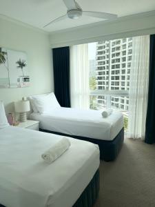 a hotel room with two beds and a window at The Crest Apartments in Gold Coast