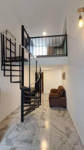 sala de estar con escalera de caracol y sofá en Departamento Loft B en Orizaba