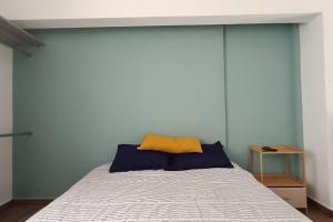 a bed with a yellow pillow on top of it at Departamento Loft B in Orizaba