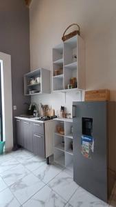 una cocina con nevera de acero inoxidable y estanterías en Departamento Loft B, en Orizaba