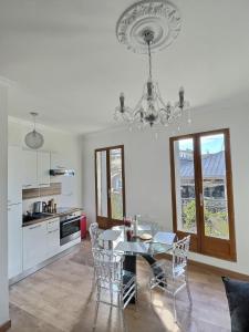 a dining room with a table and a chandelier at Appartement de charme avec balcon au pied des commerces in Béziers