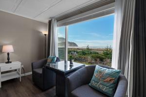 a living room with a couch and a table and a window at The Tides by the Sea in Seaside