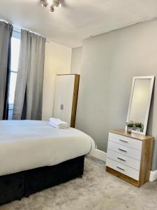 Comfortable flat in Stokes Croft في بريستول: غرفة نوم مع سرير مع مرآة وخزانة