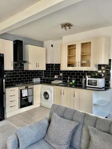 Comfortable flat in Stokes Croft في بريستول: غرفة معيشة مع أريكة في مطبخ