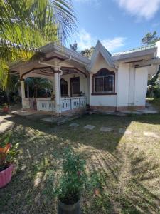 Casa blanca con porche y palmera en Banaga Residence, en Talibon