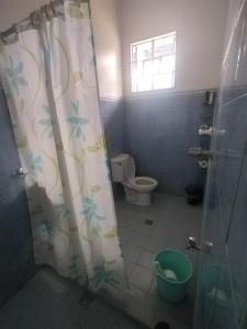 a bathroom with a toilet and a shower curtain at Banaga Residence in Talibon