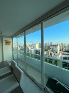 Habitación con baño privado en un piso 24 con todo lo necesario في مدينة باناما: شرفة مع أريكة وإطلالة على المدينة