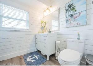a white bathroom with a toilet and a sink at Pelicans Perch in Ponte Vedra Beach
