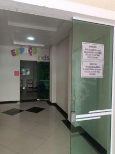 une porte dans un bâtiment avec un panneau sur celui-ci dans l'établissement Bombinhas Summer Beach, à Bombinhas