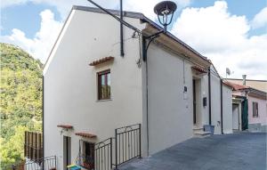 Biały budynek z lampką uliczną obok niego w obiekcie Cozy Home In Torraca With Wifi w mieście Torraca