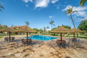 a pool with tables and umbrellas and chairs at Kaanapali Royal Q302-Oceanview spacious 2 bedroom Kaanapali Royal gem in Lahaina