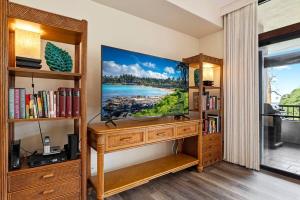 a living room with a television on a wooden entertainment center at Kaanapali Royal Q302-Oceanview spacious 2 bedroom Kaanapali Royal gem in Lahaina