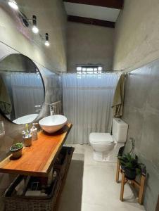 a bathroom with a sink and a toilet and a mirror at Chacra El Timbó in Tacuarembó